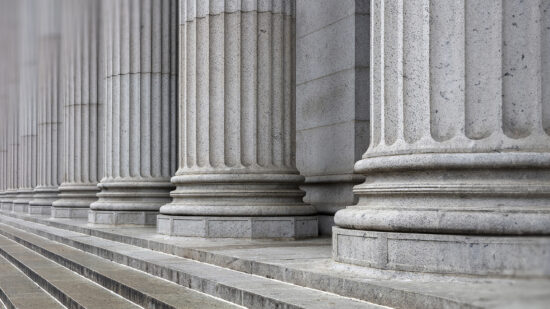 Stone colonnade and stairs detail. Classical pillars row in a building facade